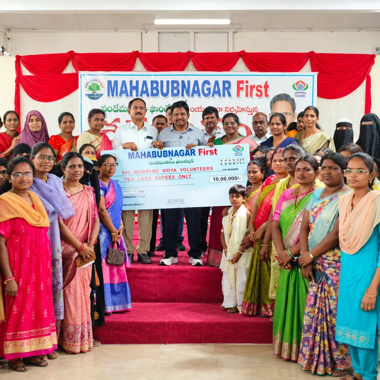 Yennam Srinivas Reddy and Vidya Volunteers hold a Mahabubnagar First cheque for ₹10 lakh supporting 100 Vidya Volunteers
