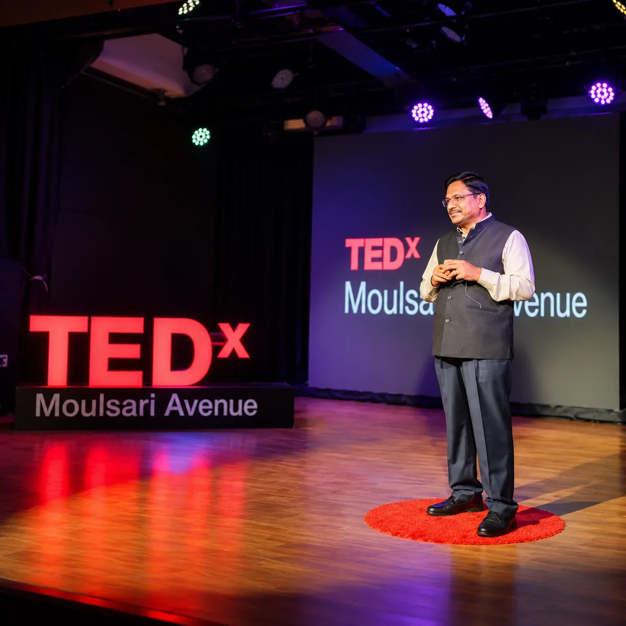 Yennam Srinivas Reddy speaking on stage at TEDx Moulsari Avenue